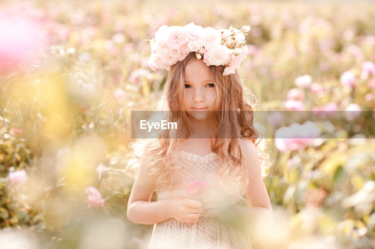 Portrait of cute girl wearing wreath at farm