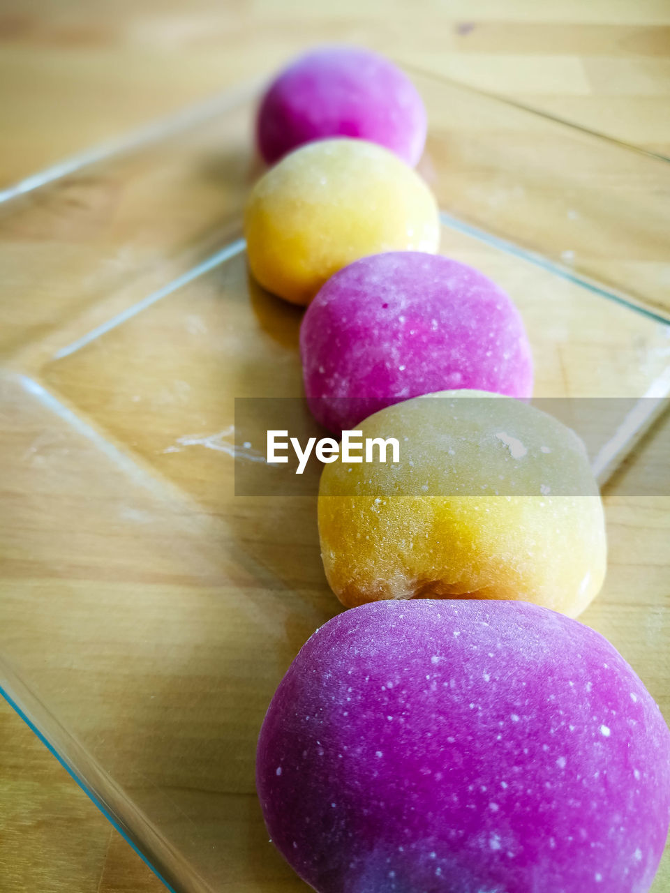 Colourful japanese mochi in a transparent plate on wooden background.