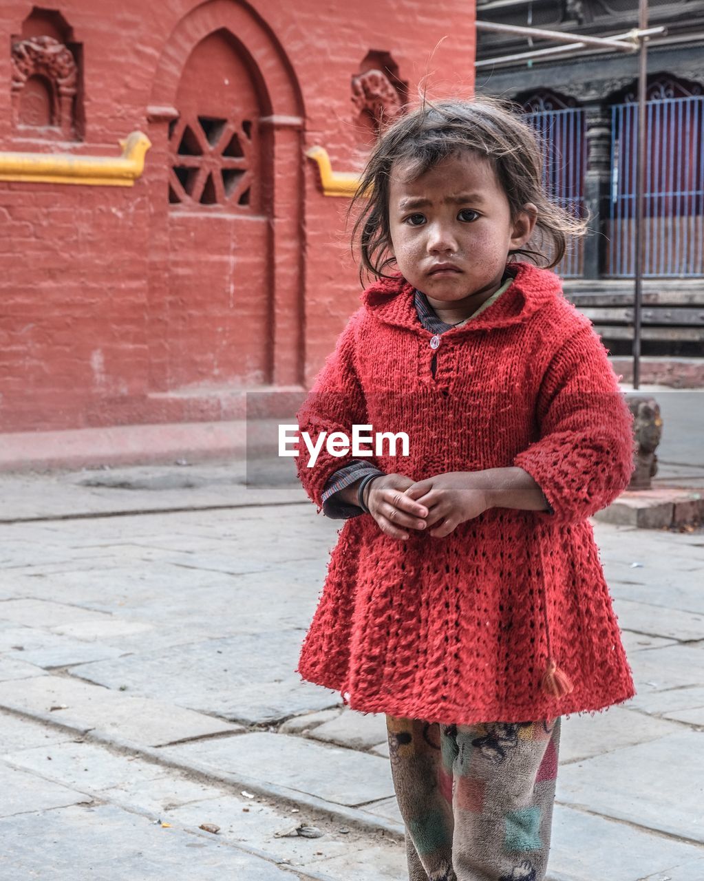 Portrait of girl standing on footpath