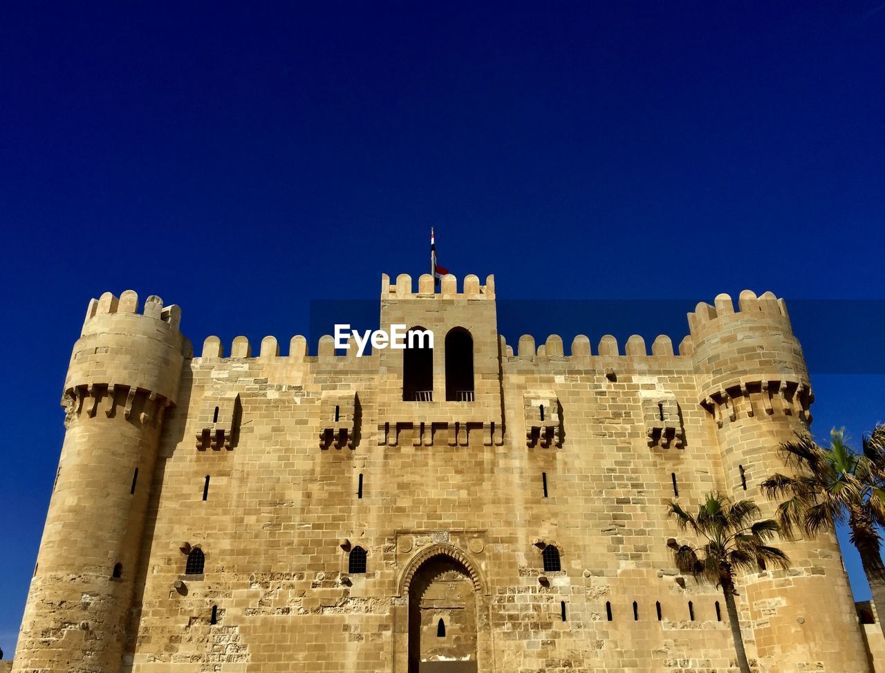 Low angle view of historic building against clear blue sky of qaitbay castle