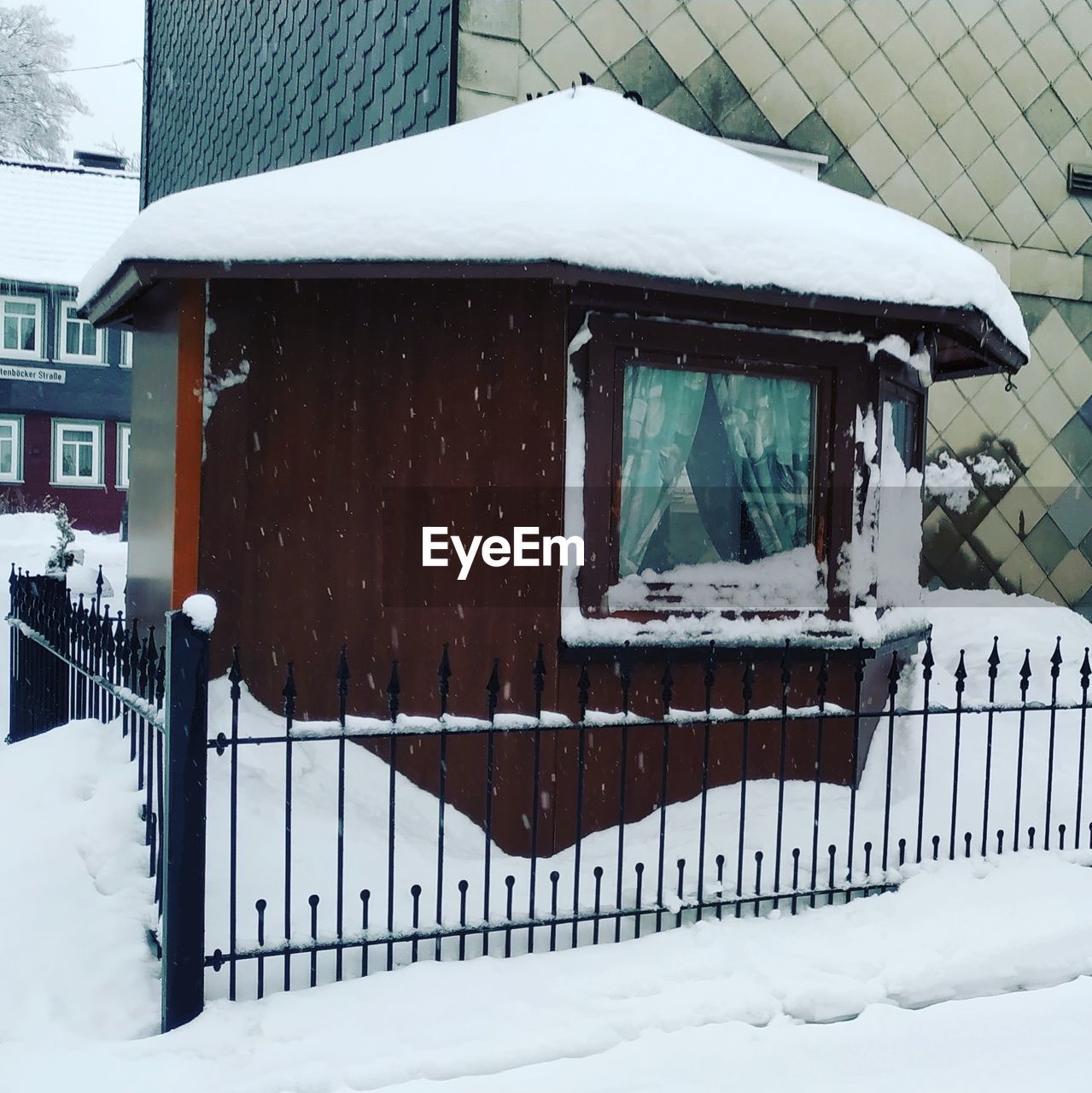 SNOW COVERED HOUSE BY FENCE AGAINST MOUNTAINS