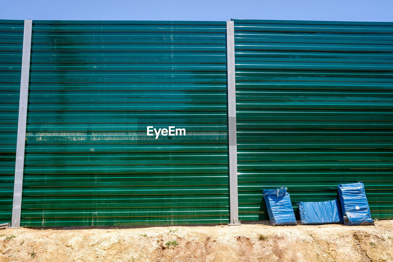 blue, architecture, wall, built structure, building exterior, no people, day, closed, facade, window covering, nature, metal, shutter, outdoors, building, sunlight, protection, corrugated iron, iron, wood, wall - building feature, security, green