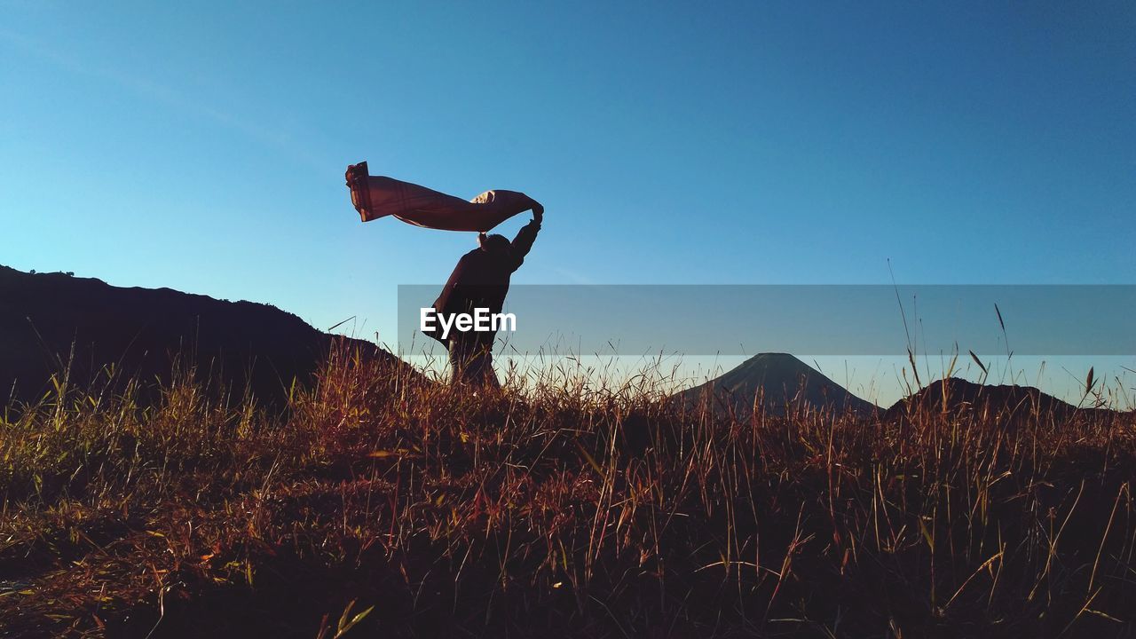 Side view of man on field against sky