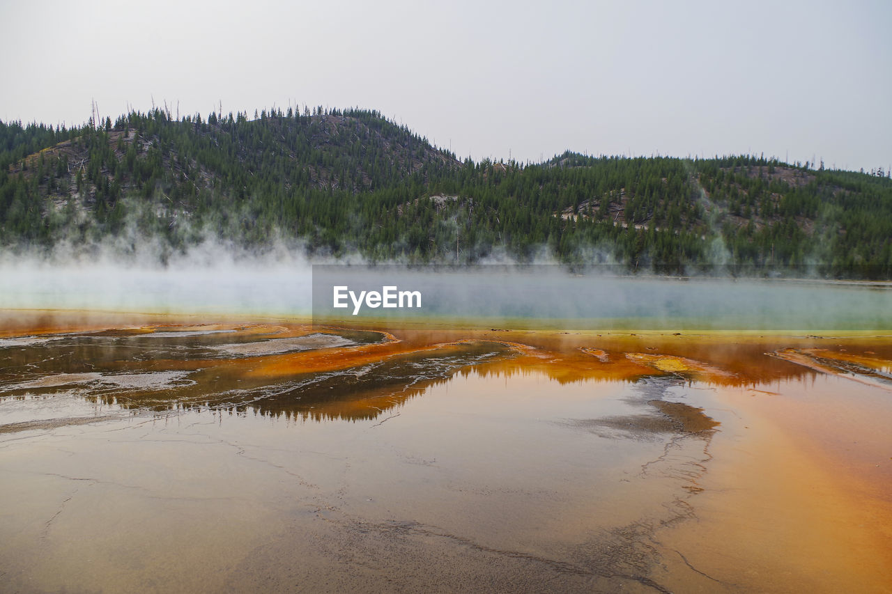 Steam emitting from geyser against clear sky