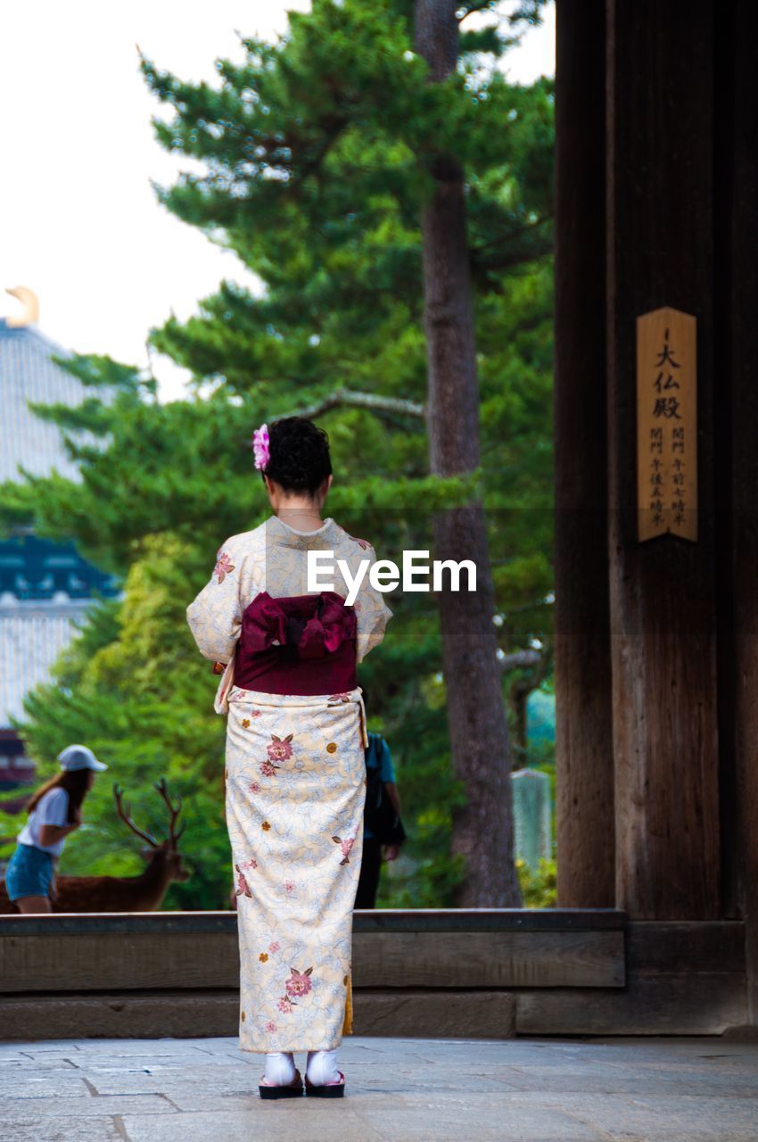 Rear view of woman in kimono outside temple