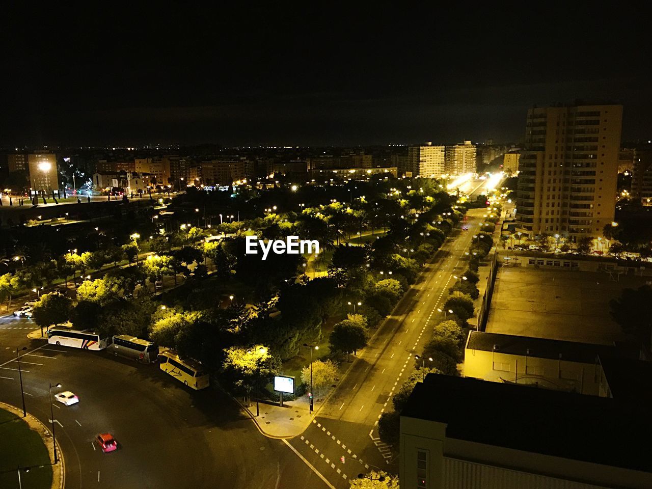 HIGH ANGLE VIEW OF ILLUMINATED CITY STREET AT NIGHT