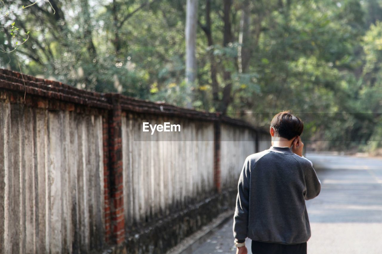 Rear view of man walking on road