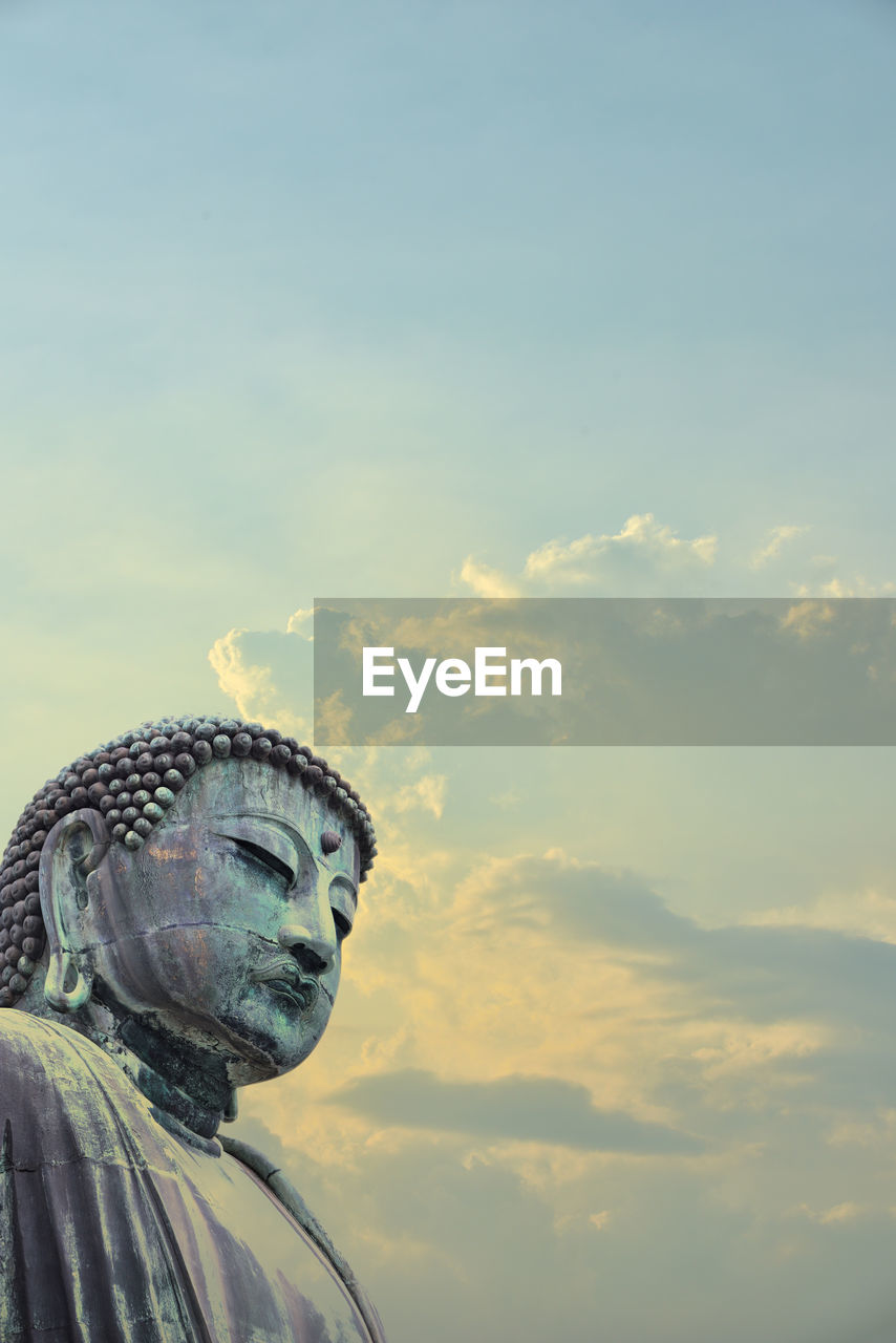 CLOSE-UP OF STATUE AGAINST SKY