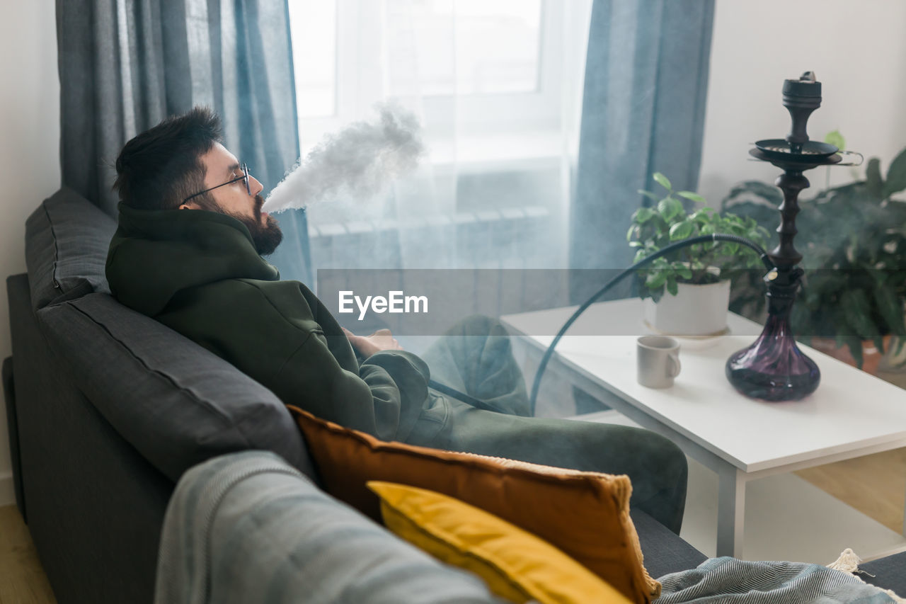 rear view of woman sitting on sofa at home