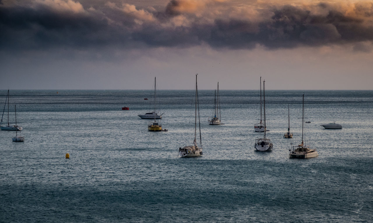 Sailboats in sea against sky