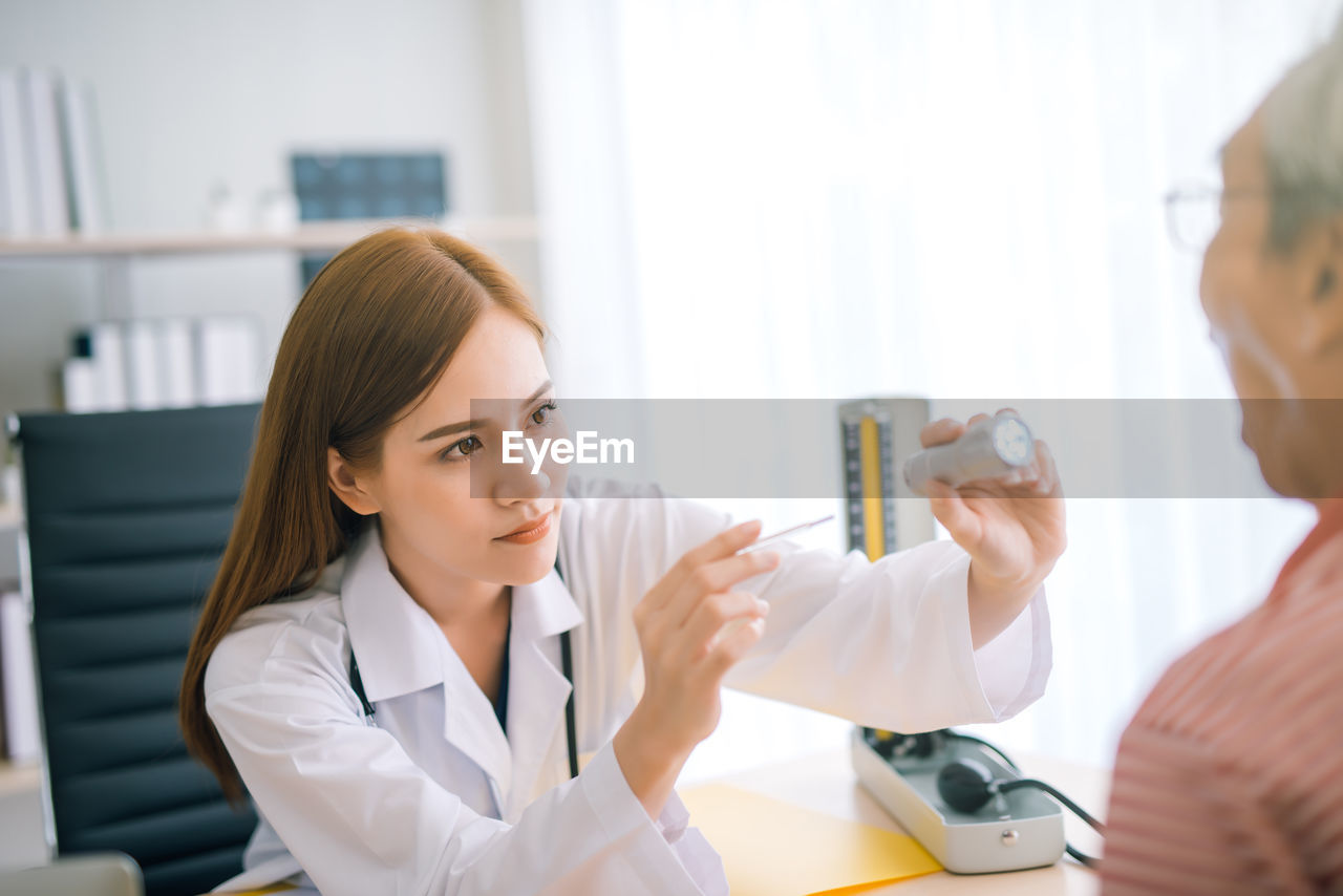 Female doctor examining male patient in hospital