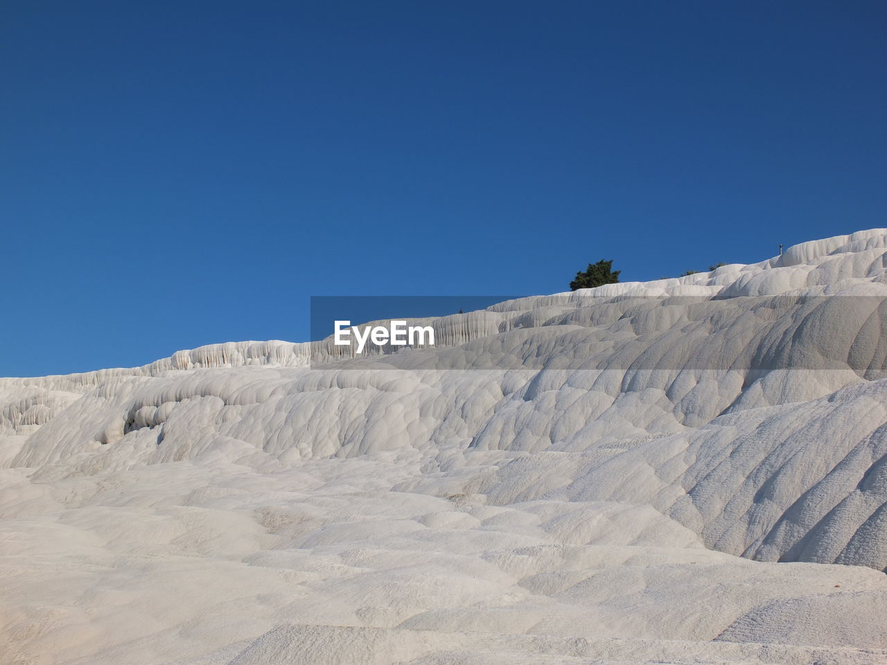 LOW ANGLE VIEW OF ROCKS AGAINST CLEAR BLUE SKY