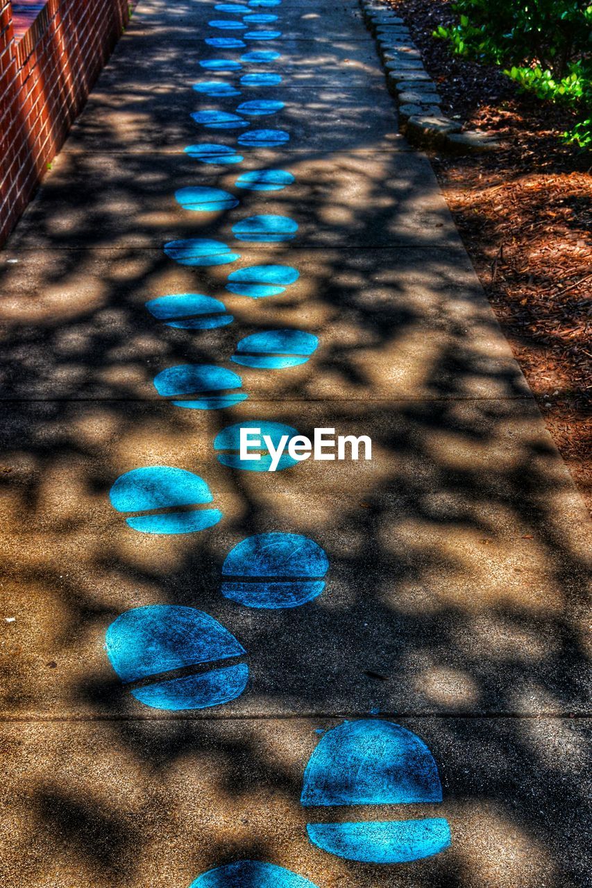 High angle view of blue footprints on footpath