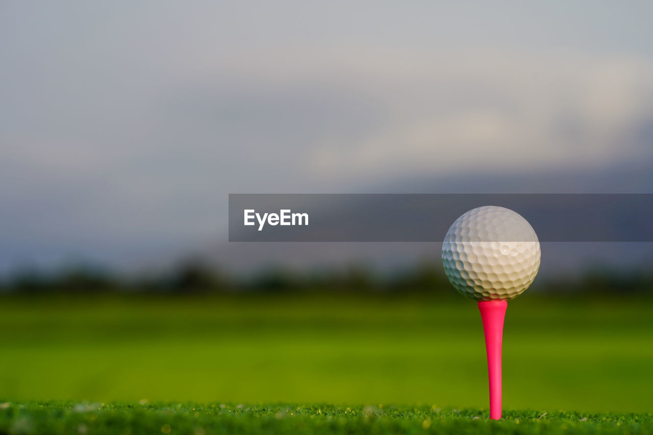 golf ball on grass against sky