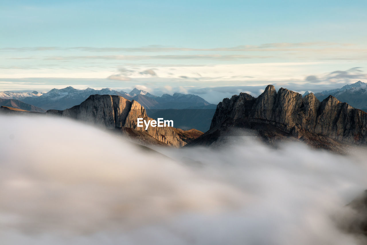 Mountains in fog at sunset in autumn. landscape with alpine mountain valley, low clouds