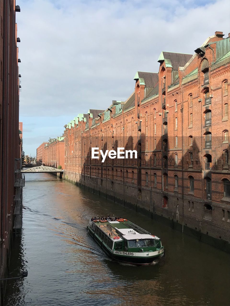 CANAL AMIDST BUILDINGS AGAINST SKY IN CITY