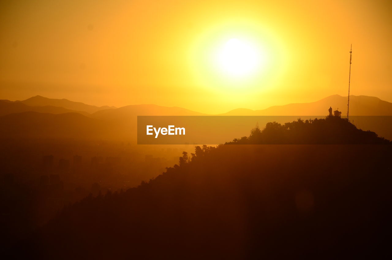 SCENIC VIEW OF SILHOUETTE MOUNTAIN AGAINST ORANGE SKY