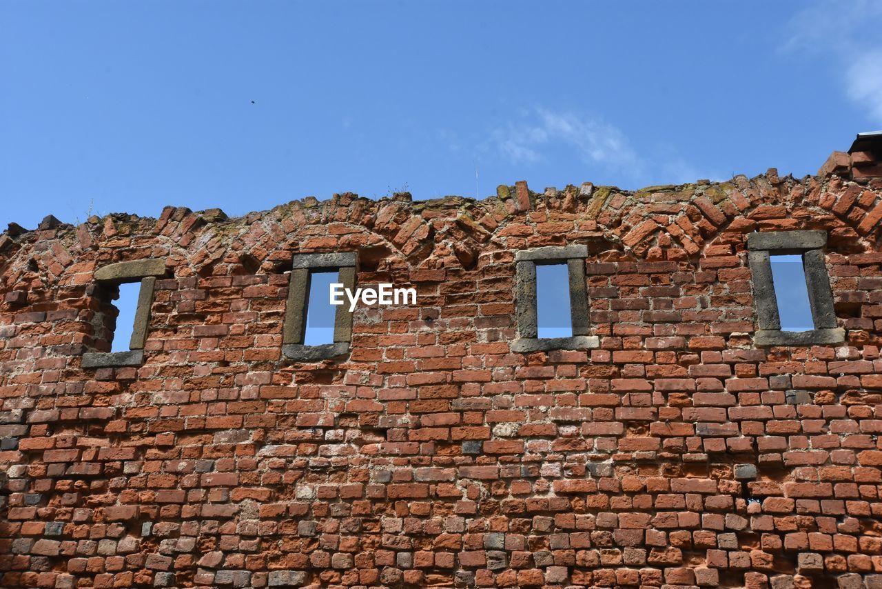 LOW ANGLE VIEW OF BRICK WALL AGAINST SKY