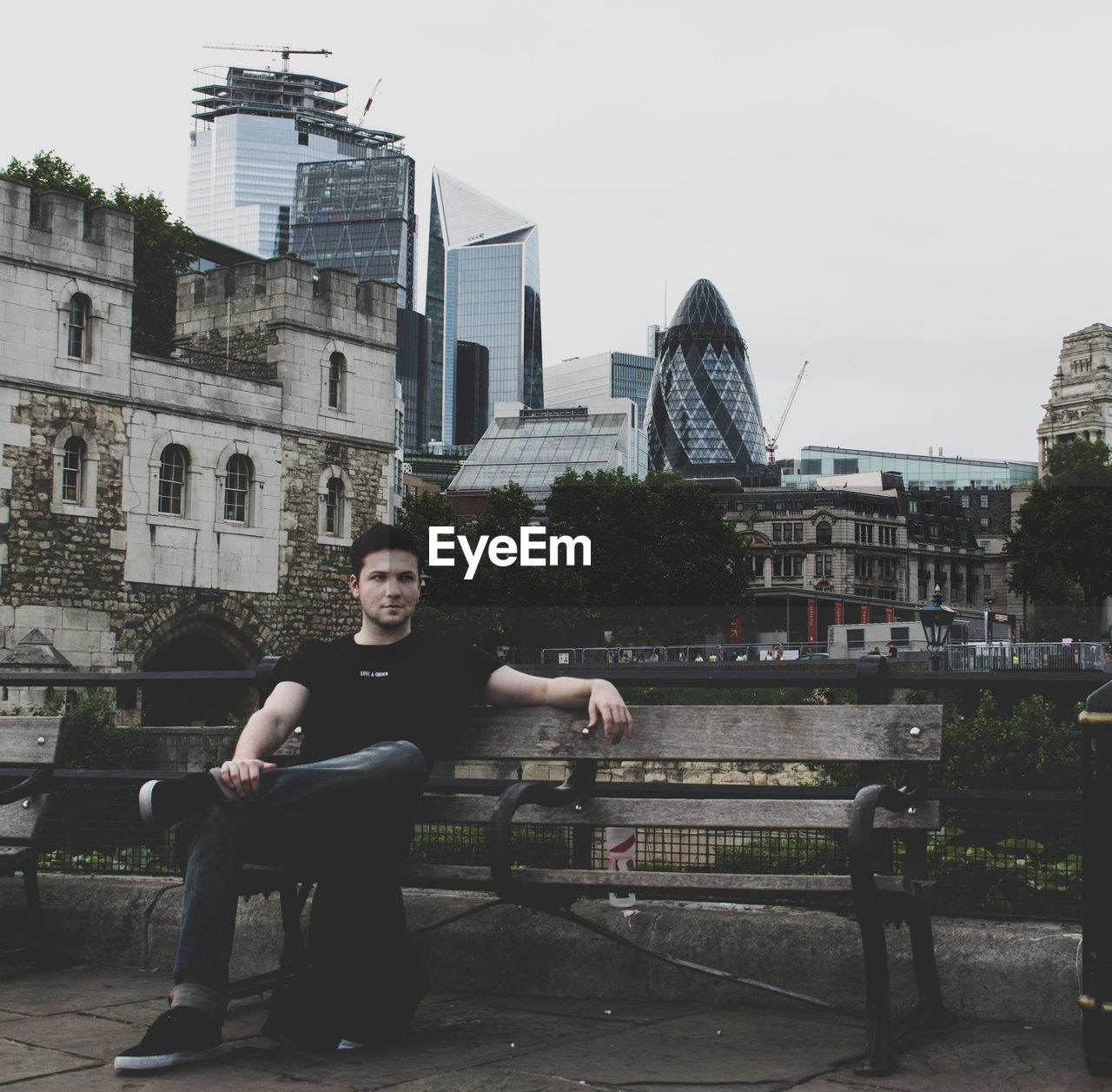 Portrait of young man against buildings in city