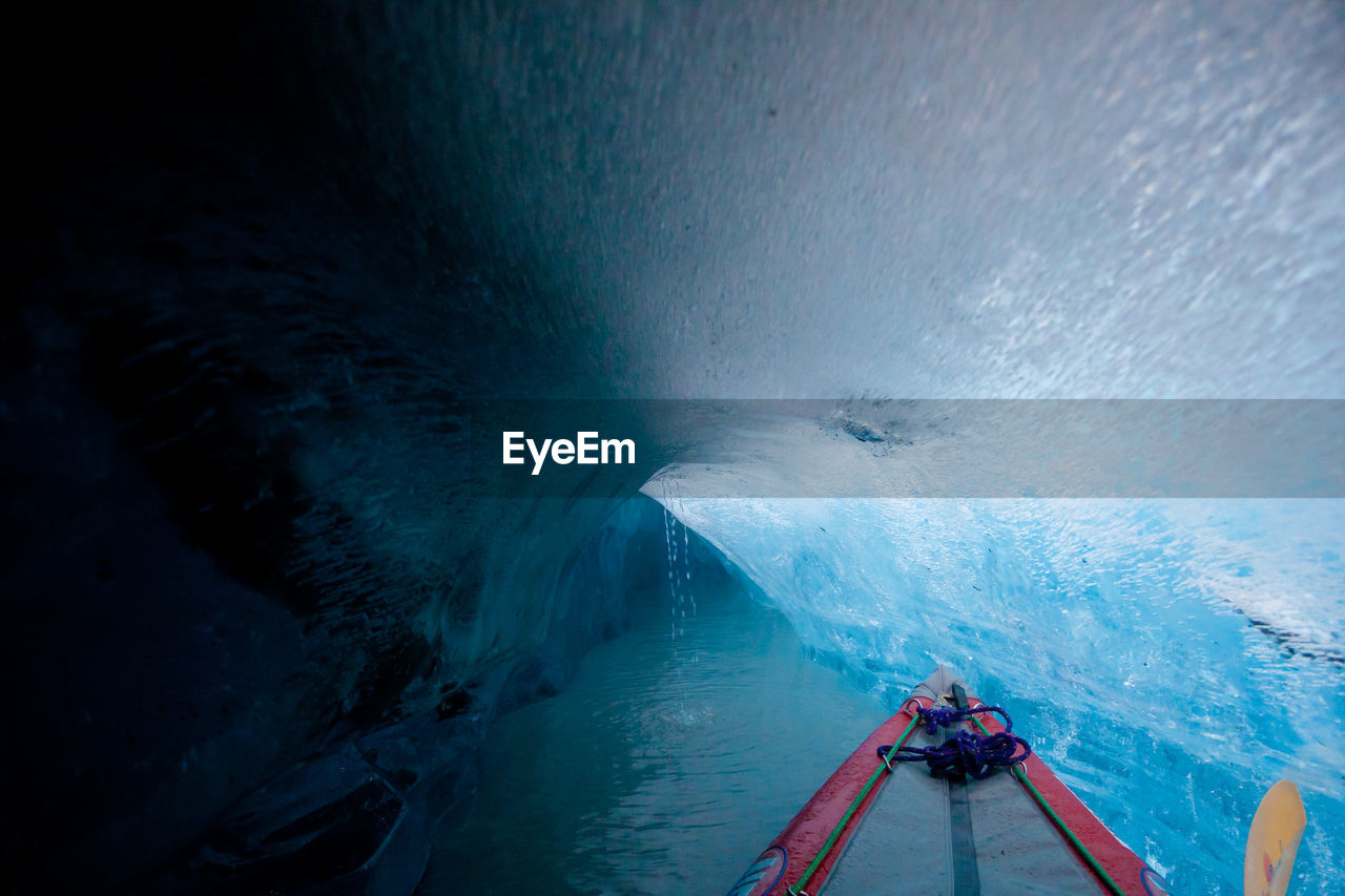 Cropped image of boat on sea in ice cave