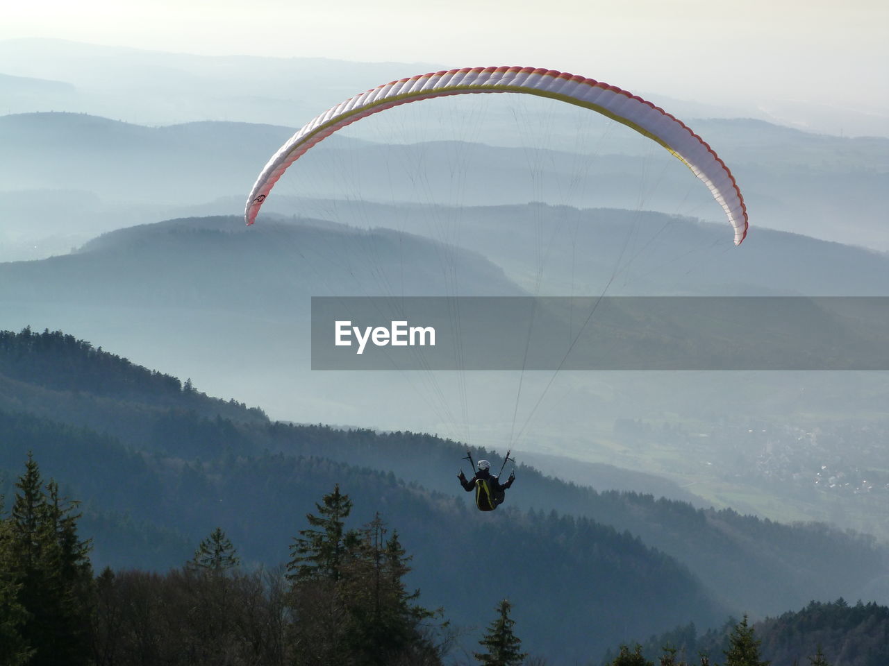 Young man paragliding over mountains