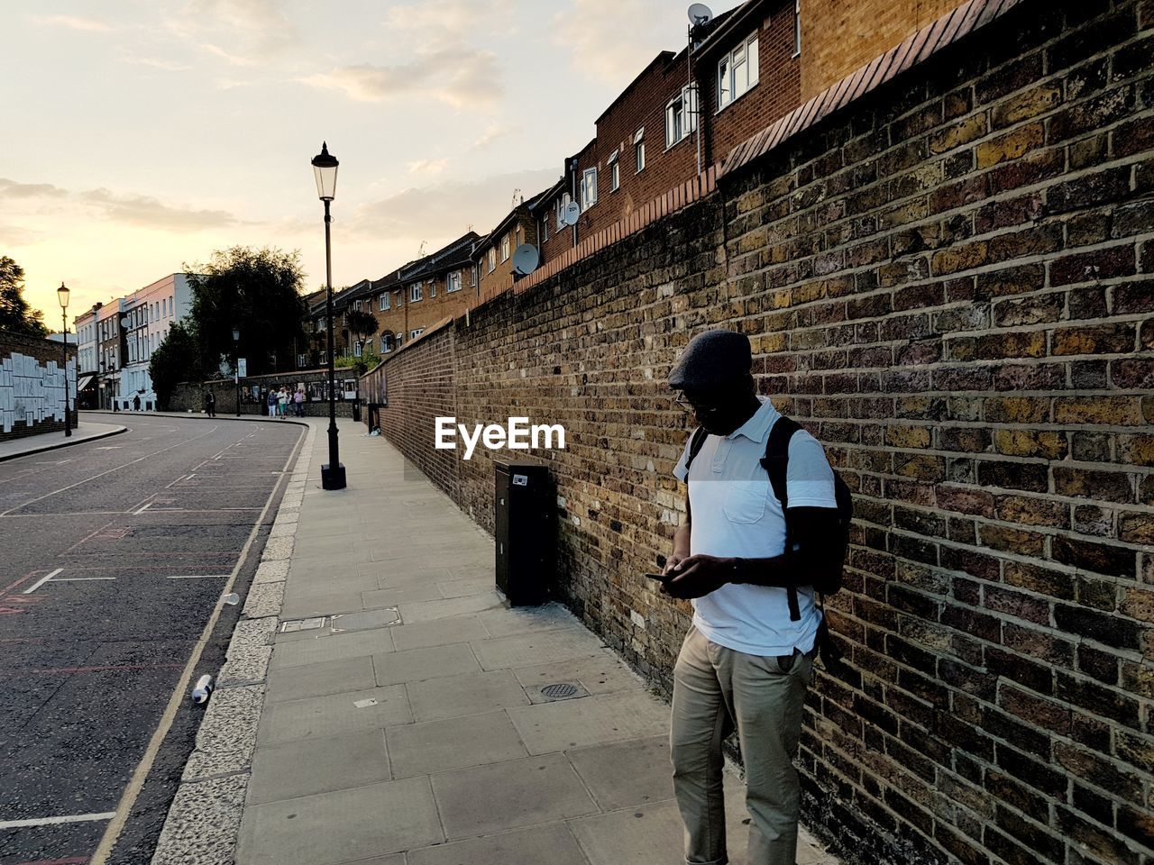 Man standing on street in city during sunset