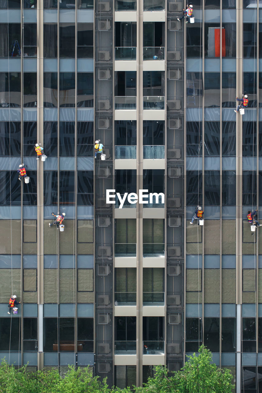 High-rise window washers with scaffold system working on windows of skyscraper