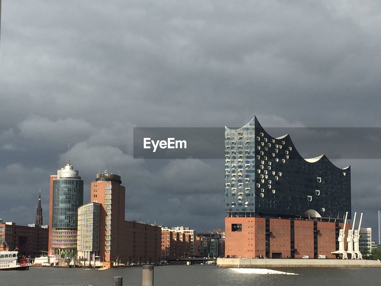 Modern buildings in city against cloudy sky