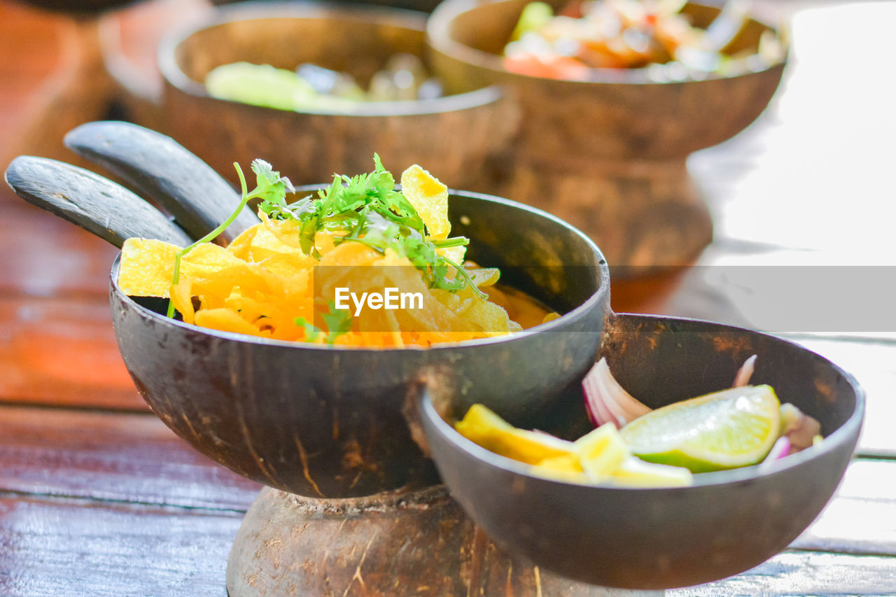 Northern thai curry noodles with chicken serve in coconut shell on wooden table. 