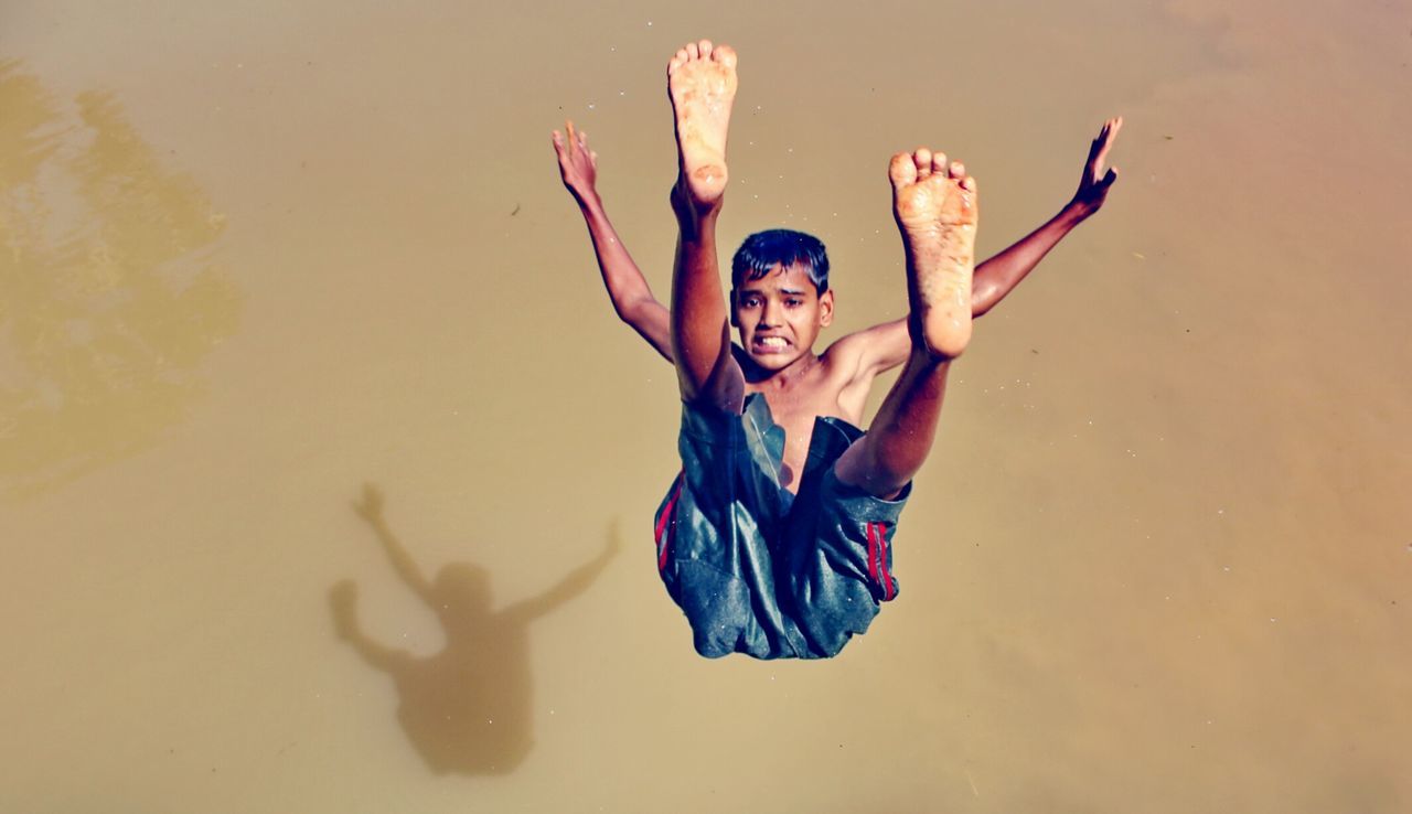 PORTRAIT OF SMILING YOUNG WOMAN IN WATER