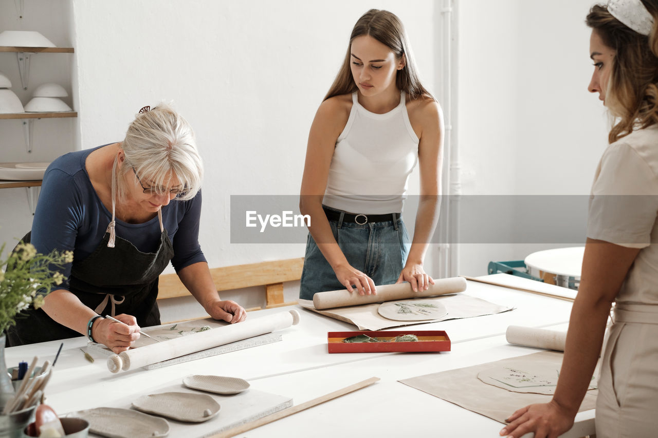 Pottery workshop in studio. people working with clay on the table. adults learning to do ceramic