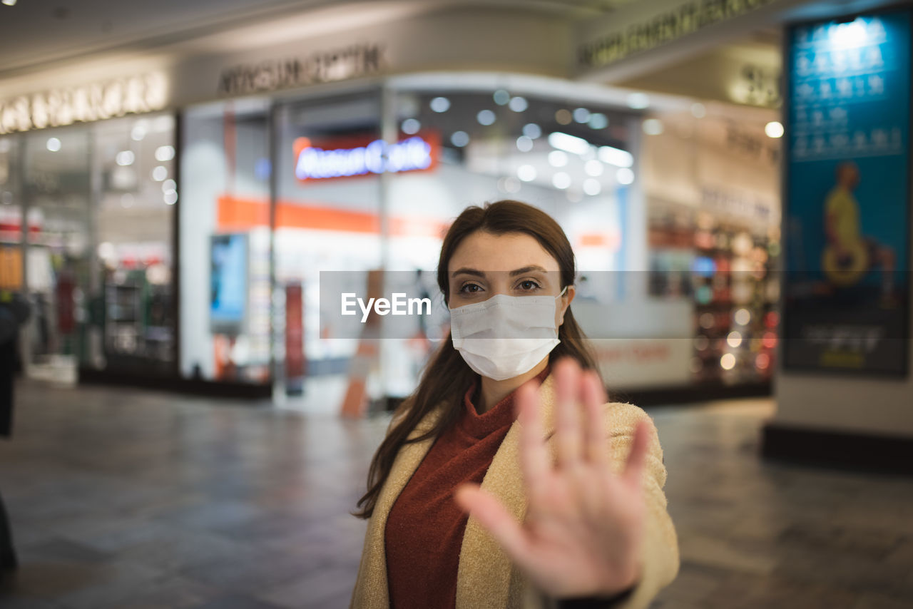 Portrait of woman wearing mask while standing at mall