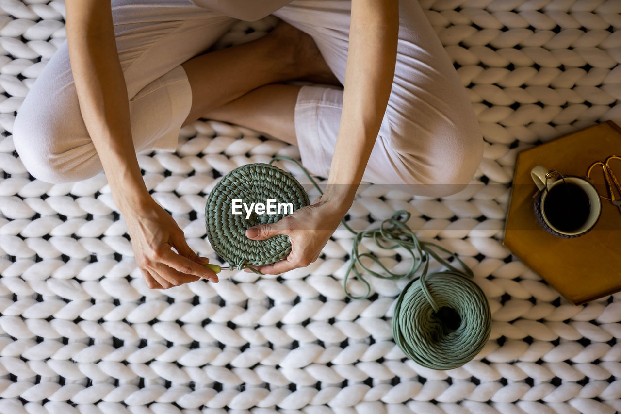 high angle view, indoors, basket, container, pattern, art, one person, food and drink, directly above, picnic basket, lifestyles, adult, textile, wicker, food, furniture, wellbeing, women