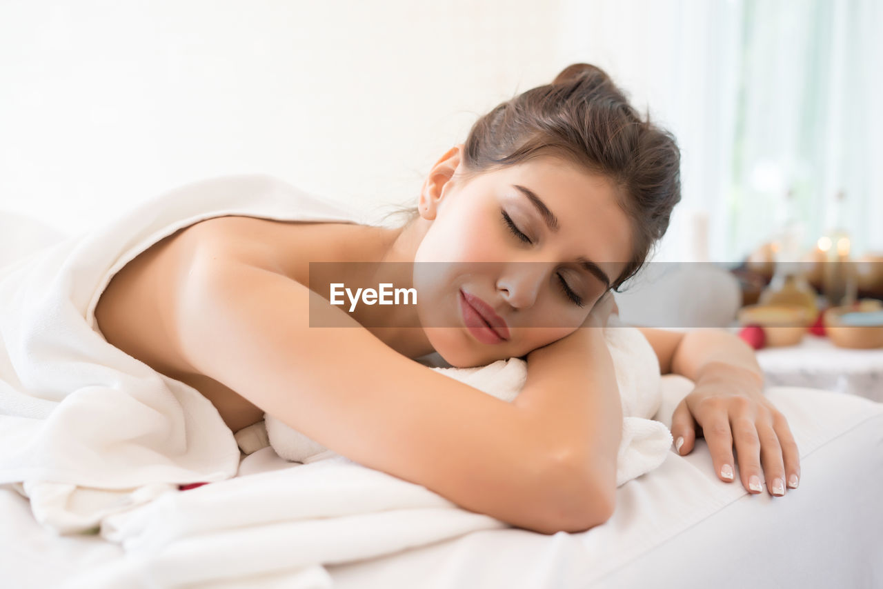 Young woman lying on massage table in spa