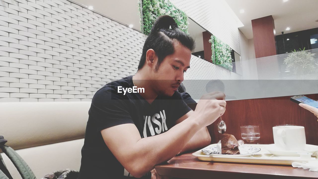 Man having food while sitting at restaurant