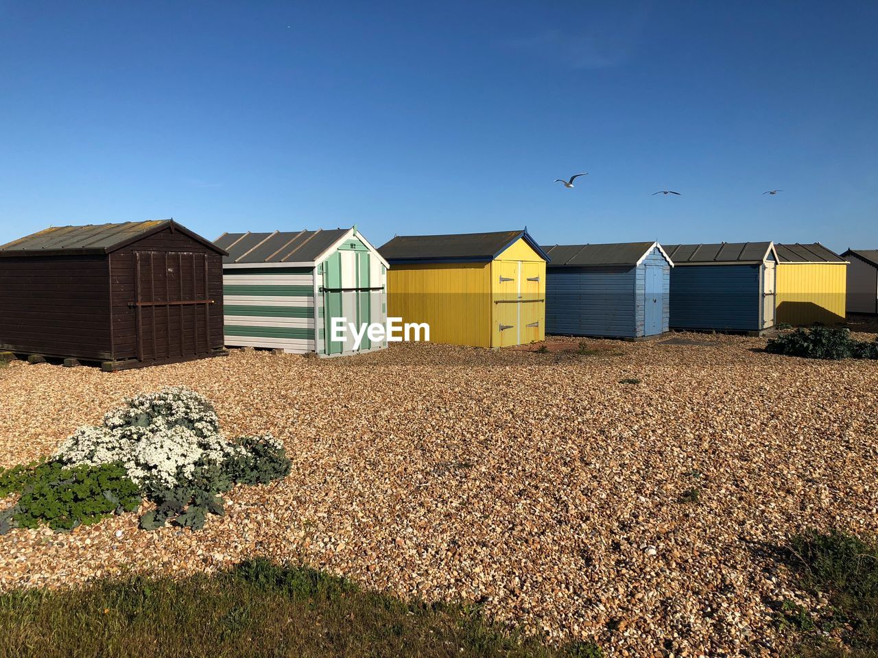 Brightly painted beach huts against clear blue sky