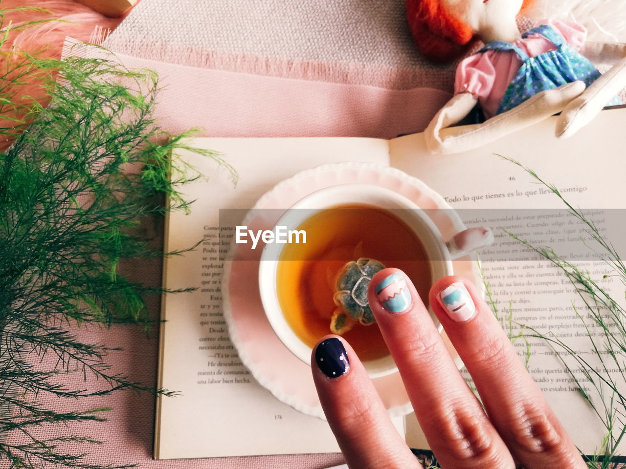 Cropped image of person holding tea cup on table