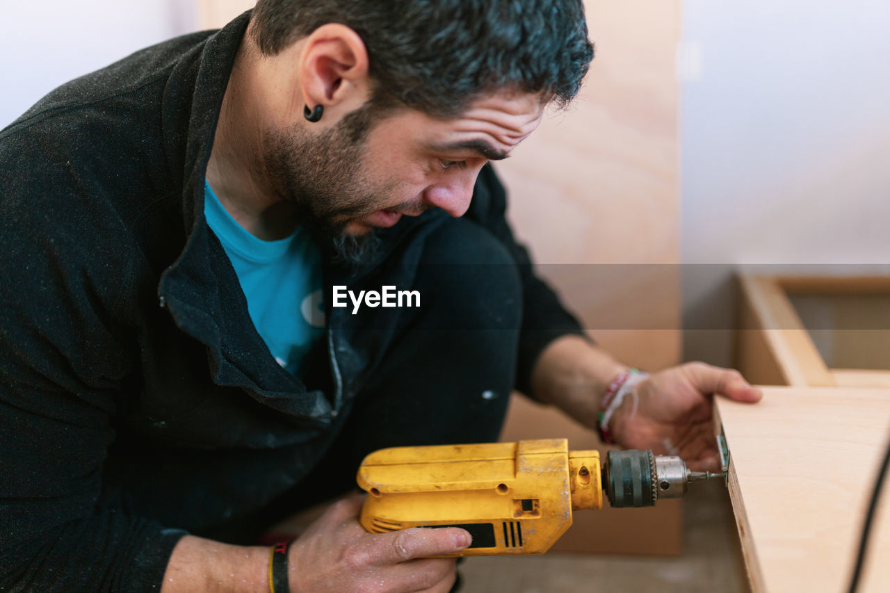 Man drilling wood in camper trailer