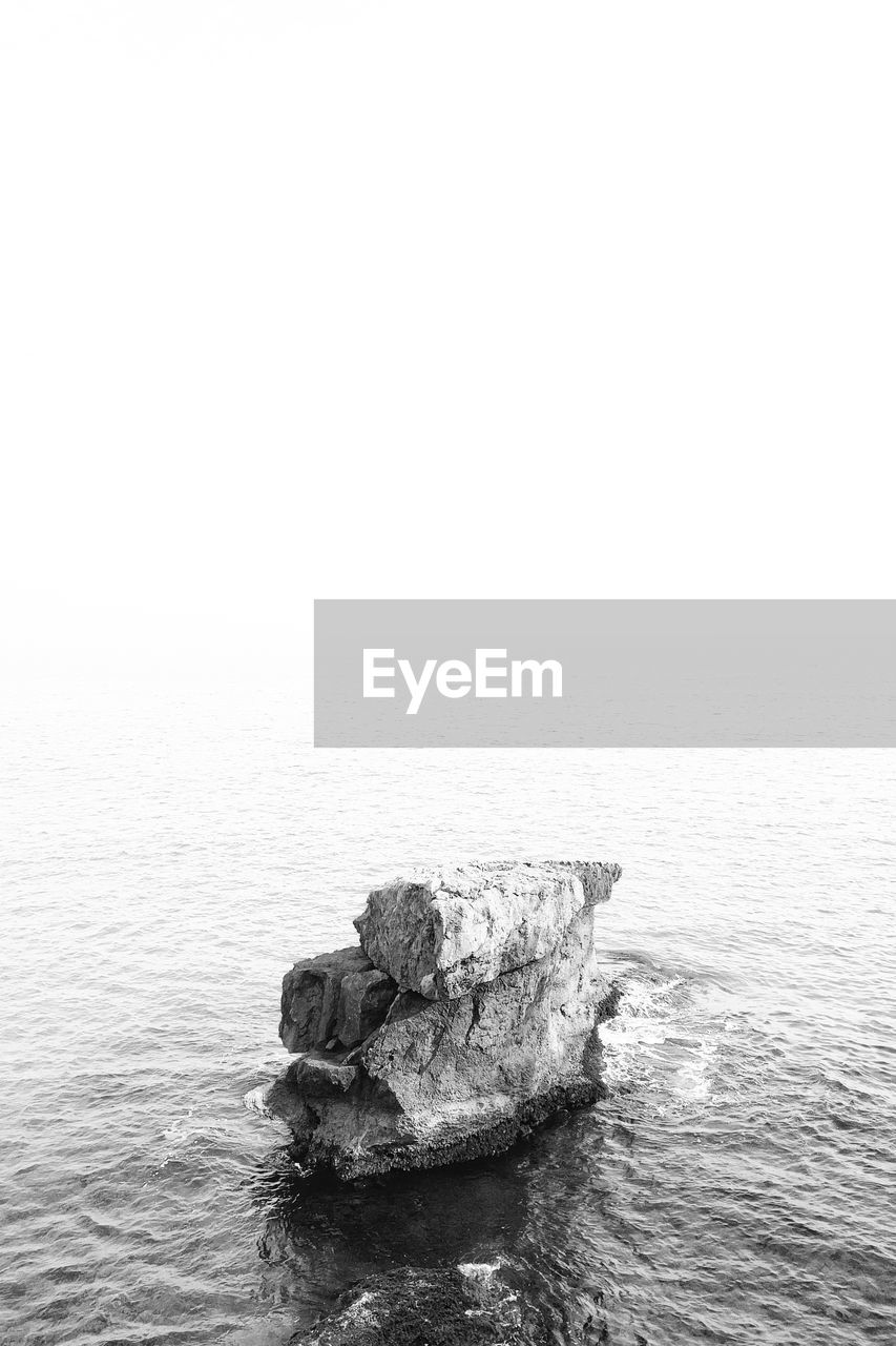 High angle view of rock structure in sea against clear sky