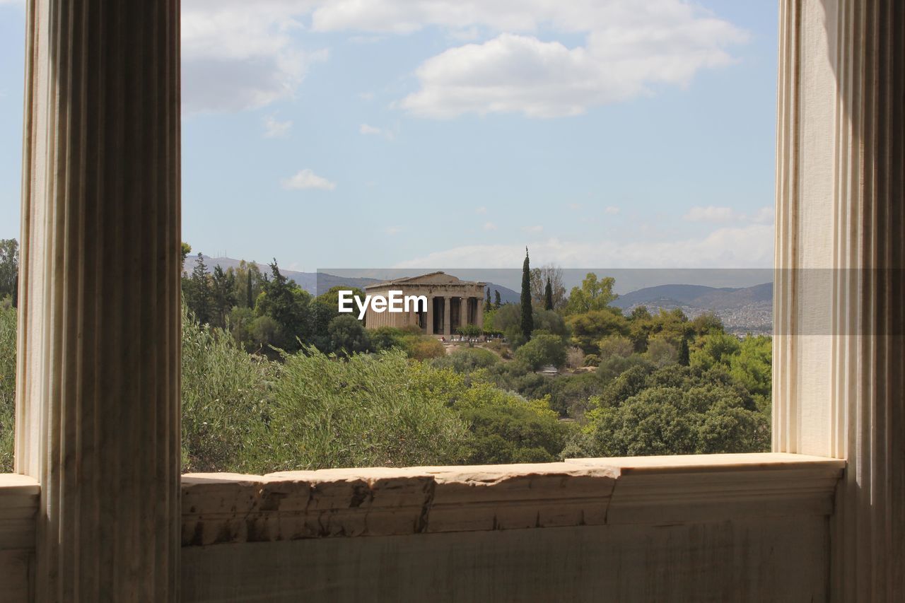 TREES AND BUILDINGS SEEN THROUGH WINDOW