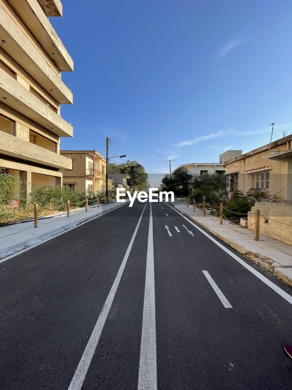 ROAD BY BUILDINGS AGAINST SKY