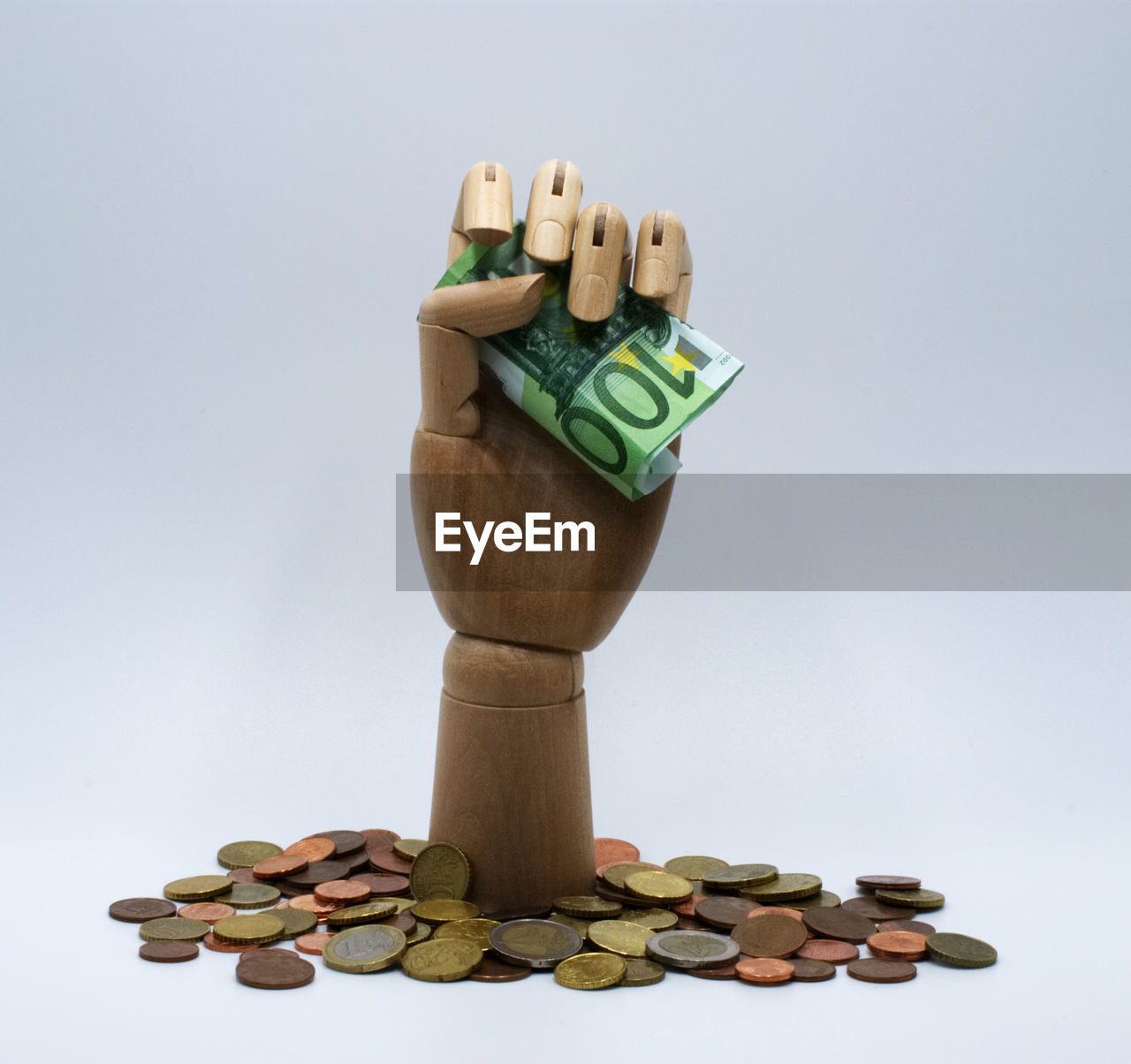 Wooden hand holding banknotes