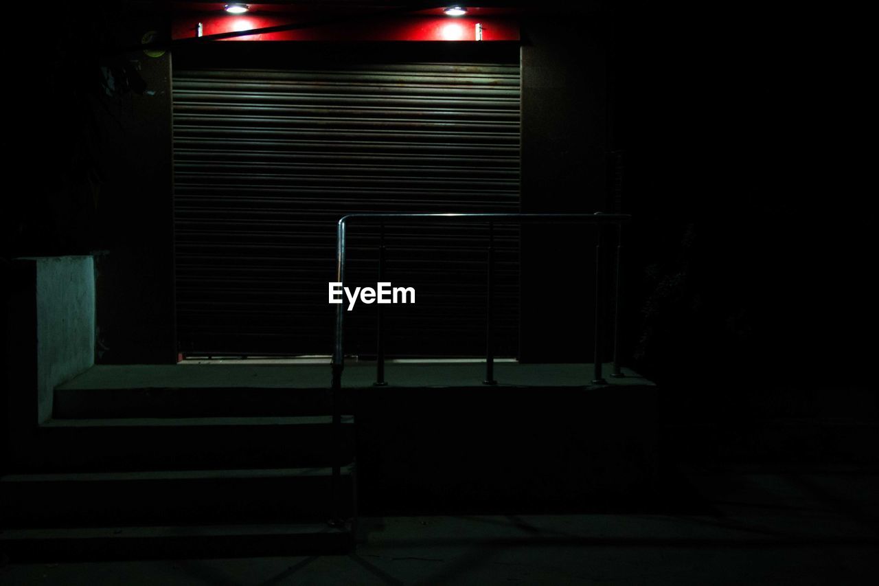 Illuminated lighting equipment by closed shutter of store at night