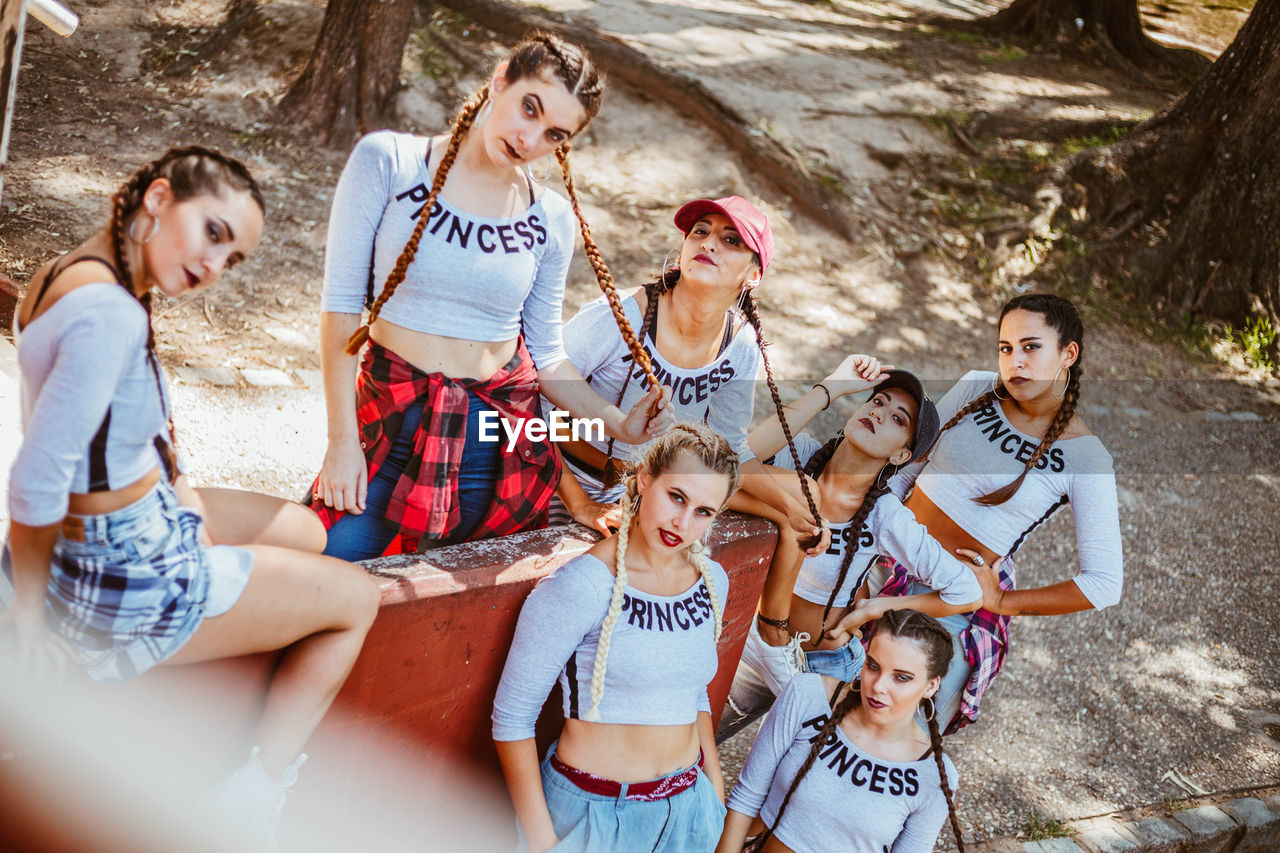 Group of friends using mobile phone while sitting in park