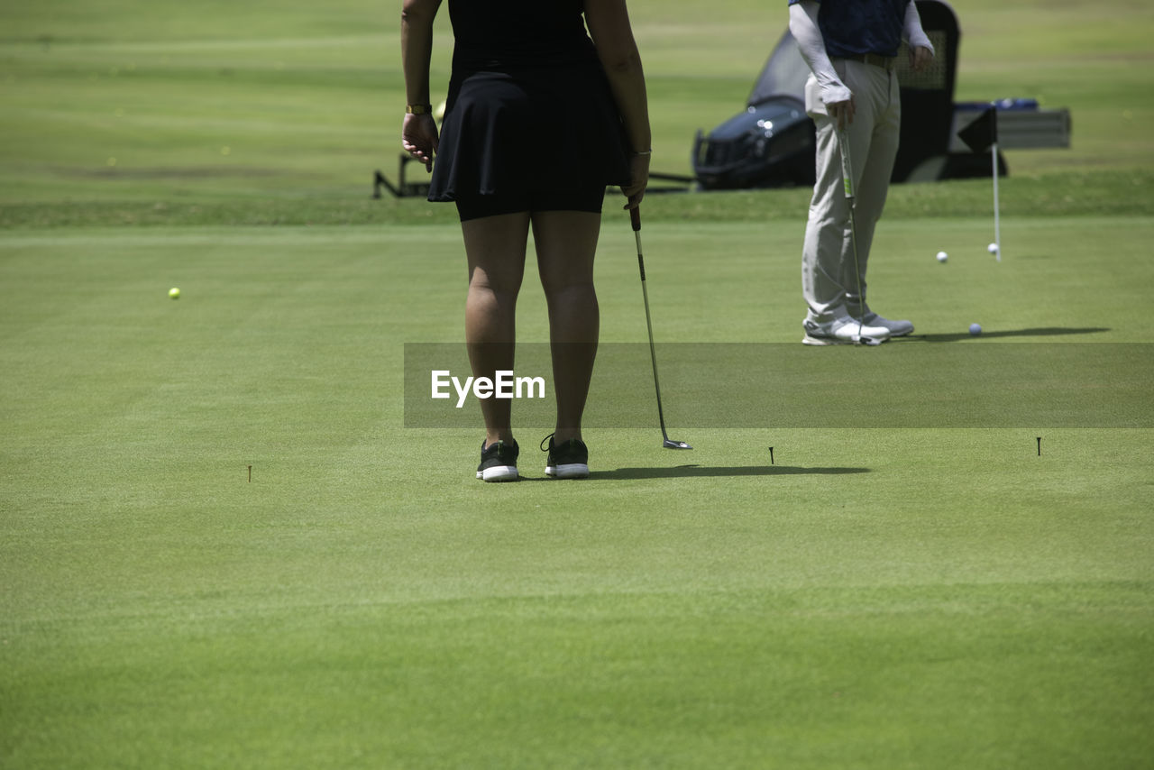 A back shot of an active woman playing golf in mexico