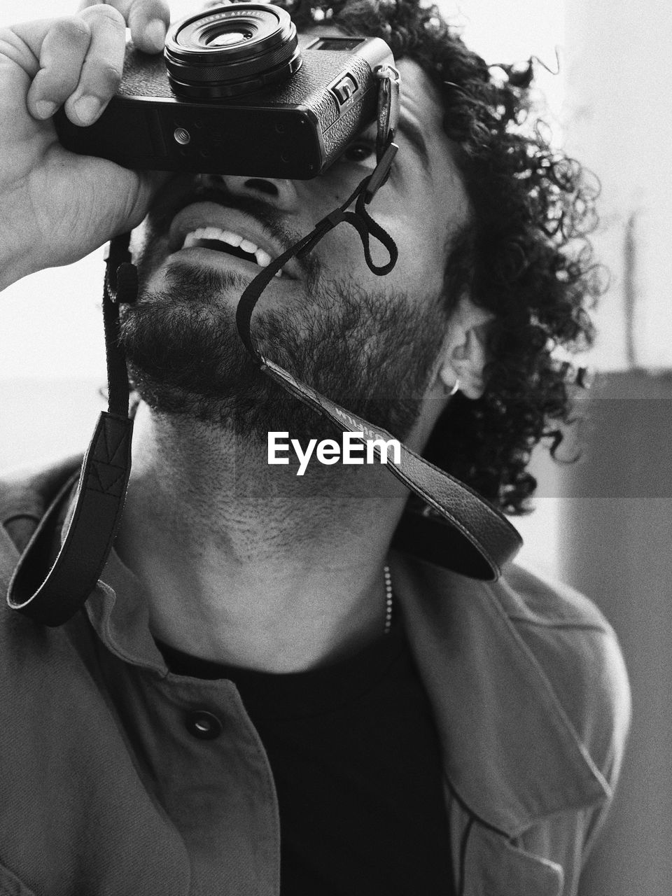 Close-up of bearded man photographing with camera