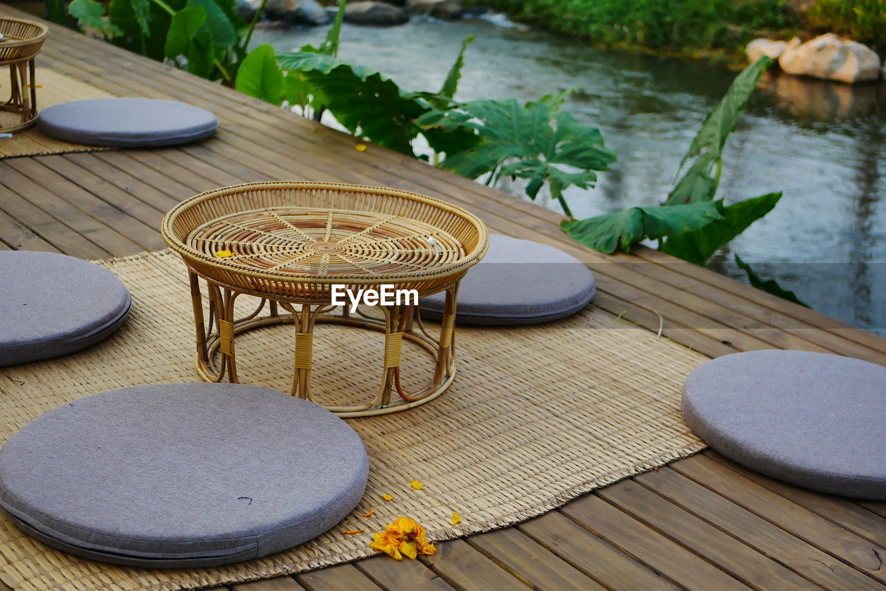 HIGH ANGLE VIEW OF EMPTY CHAIRS AND TABLE ON LAKE