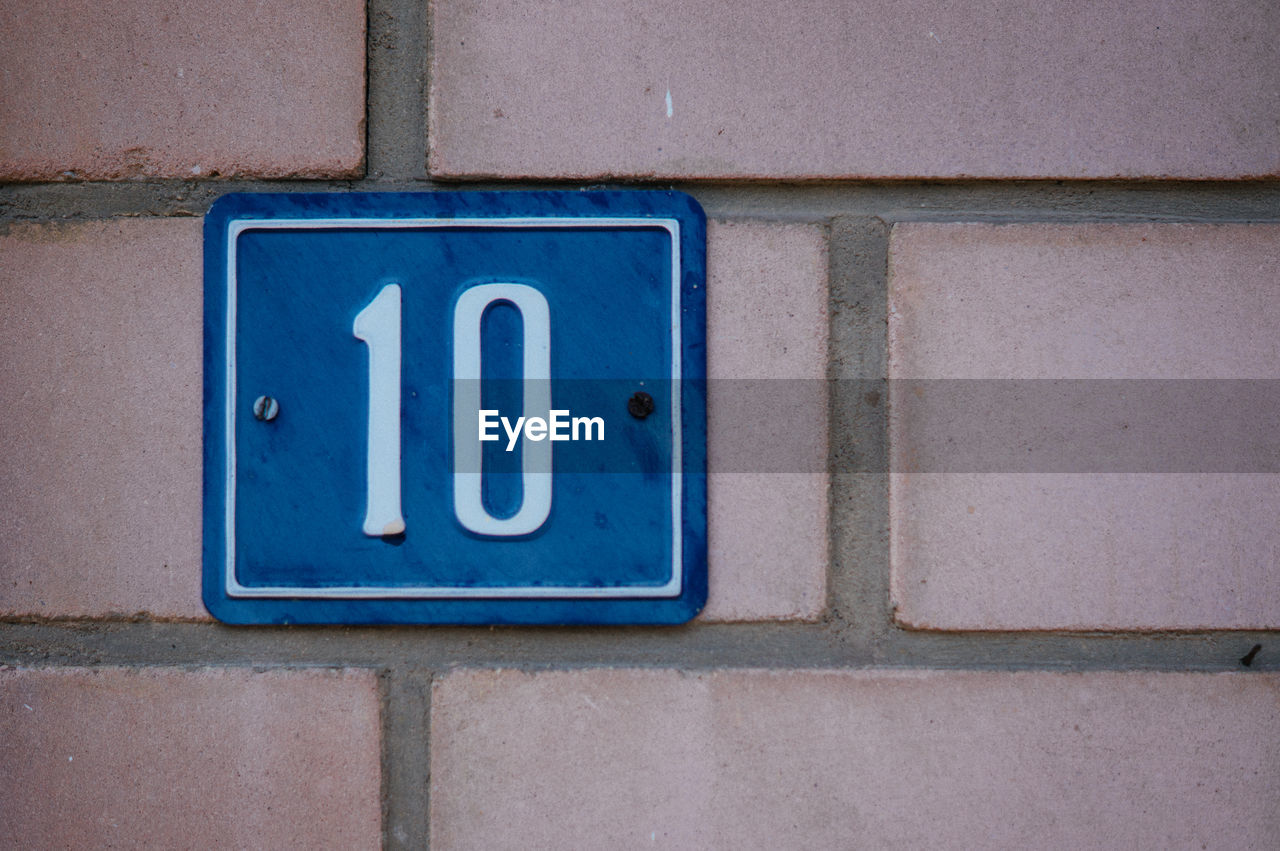 House number sign on brick wall