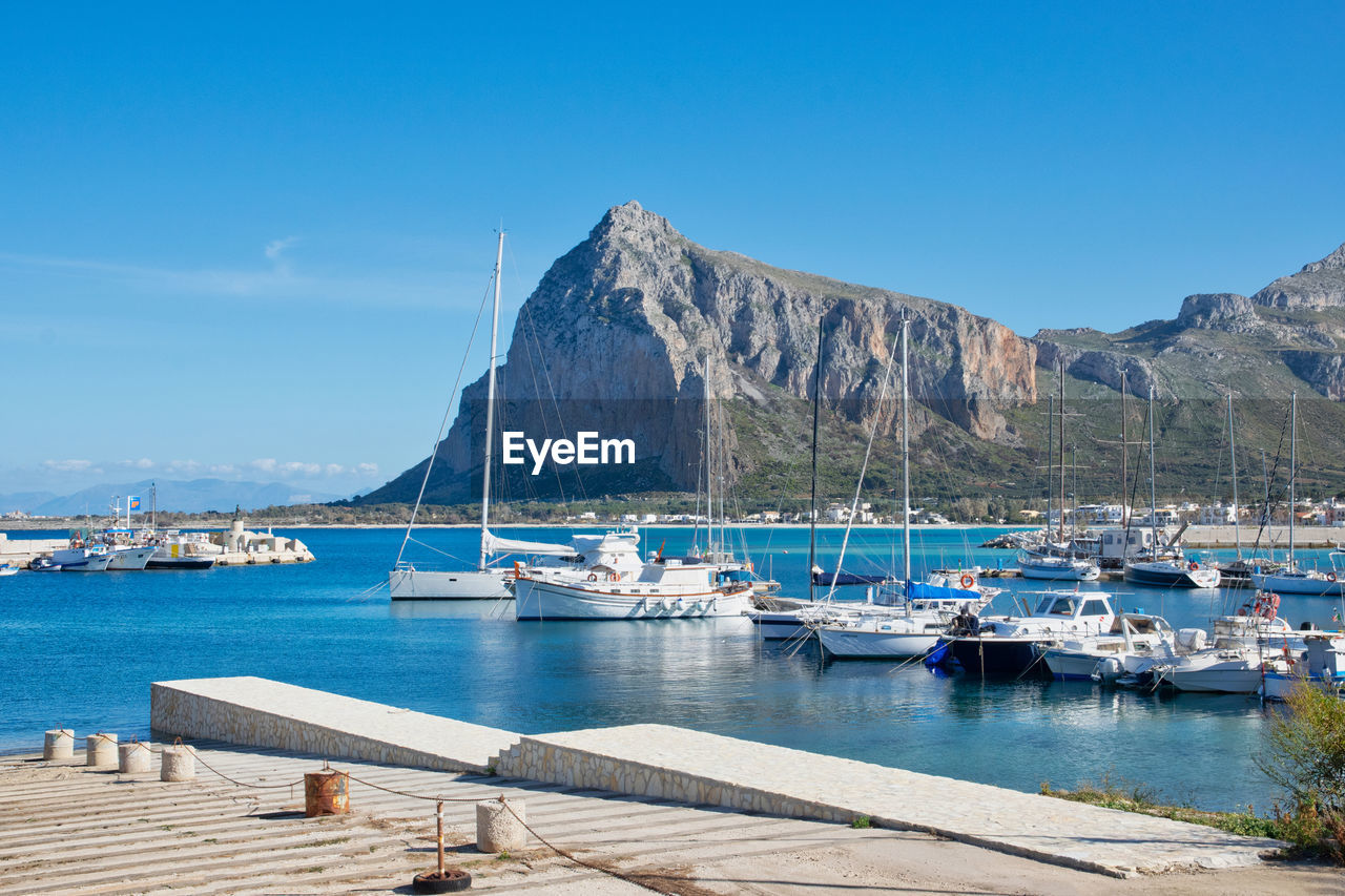 Sailboats moored in harbor