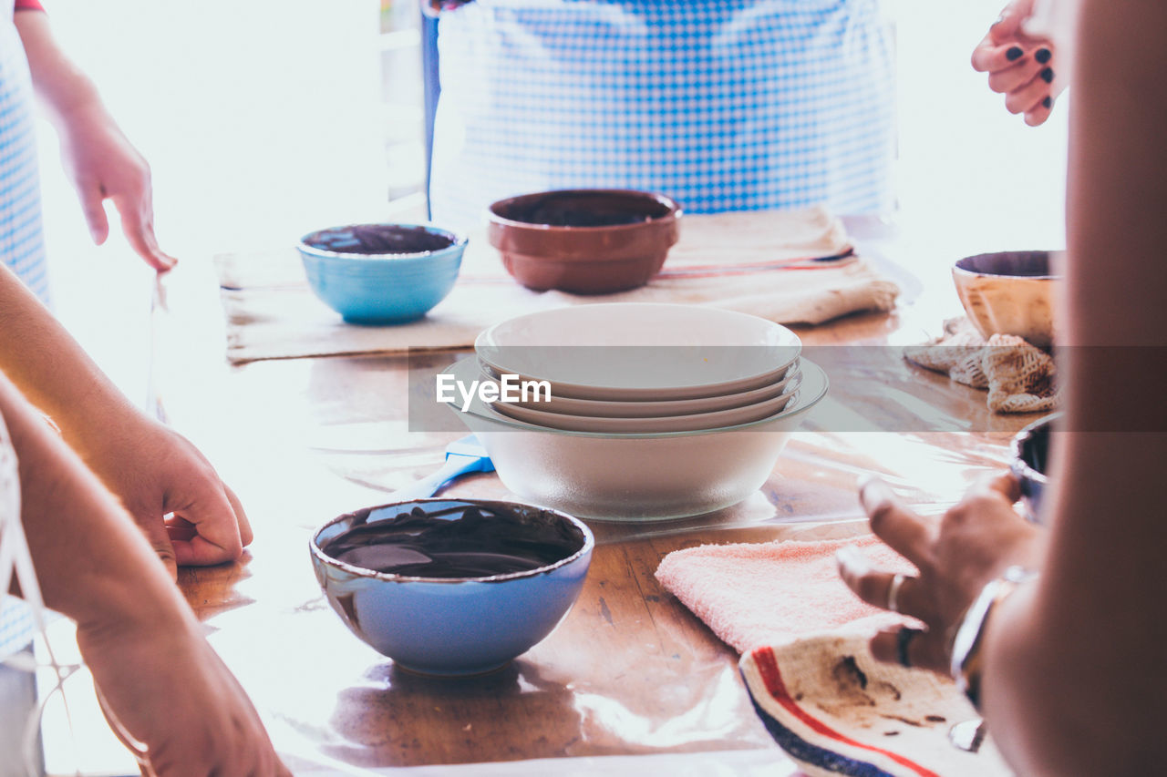 Midsection people preparing food on table